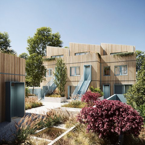 „Außenansicht eines modernen, mehrstöckigen Wohngebäudes an einem sonnigen Tag. Die Fassade ist komplett mit hellen, vertikalen Holzlatten verkleidet. Hellblaue Außentreppen führen zu den Eingängen im Obergeschoss. Im Vordergrund liegt ein moderner Innenhof mit Kieswegen und bepflanzten Beeten.“