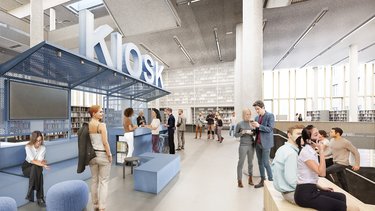 Großzügiger Innenraum mit Informationspunkt, Sitzgelegenheiten und vielen Menschen.