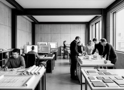 "Schwarz-Weiß-Fotografie eines modernen Architekturbüros. Mehrere Mitarbeiter arbeiten an verschiedenen Stationen: Im Vordergrund liegt Baupläne aufgerollt auf einem Tisch, im Hintergrund sitzen Personen an Computern mit großen Bildschirmen. Eine Gruppe bespricht sich in der Raummitte. Betonwände, schwarze Deckenträger, große Fenster mit Blick nach außen."
