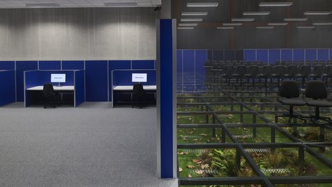 "Innenraum mit Reihen von schwarzen Stühlen auf einem transparenten Glasboden. Unter dem Glas sind Pflanzen, Erde und herabgefallene Blätter sichtbar. Seitlich befinden sich blaue Trennwände mit Arbeitsplätzen und Monitoren."