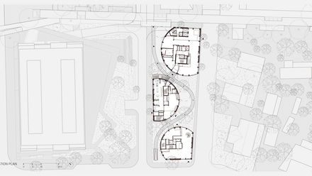 Schematischer Situationsplan (Draufsicht) eines urbanen Grundstücks: Drei halbkreisförmige, gestaffelte Baukörper stehen in einer Reihe und sind durch geschwungene Wege miteinander verbunden; links daneben ein größeres rechteckiges Bestandsgebäude, rechts Randbebauung und Baumbestand mit eingezeichneten Wegen und Freiflächen. Eingetragen sind Grundrisse der drei Gebäude mit inneren Treppen- und Erschließungszonen, umlaufende Gehwege, Bäume als Kreissymbole sowie Pflanzflächen und Platzstrukturen. Unten links Maßstabsleiste und Nordpfeil.