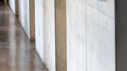 Detailansicht einer Betonwand mit Licht- und Schattenverlauf im Innenraum.