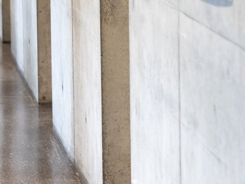 Detailansicht einer Betonwand mit Licht- und Schattenverlauf im Innenraum.