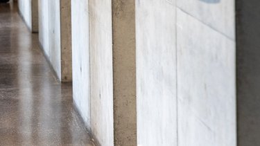 Detailansicht einer Betonwand mit Licht- und Schattenverlauf im Innenraum.