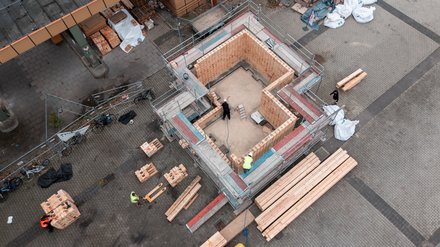 Luftaufnahme eines im Bau befindlichen Holzgebäudes mit Gerüst.