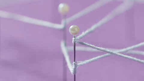Detailaufnahme eines Netzwerk-Knotens: Weiße Perlkugel auf einer Metallstange mit verschwommenen Verbindungslinien im Hintergrund auf lila Fläche, zeigt Struktur und Verbindungen