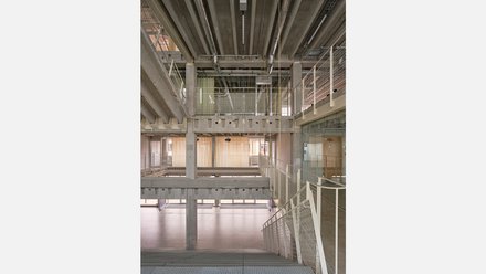 Mehrstöckiges steiniges Treppenhaus mit hellem Innenraum und weißen Geländer.