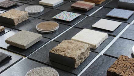 Eine Sammlung von verschiedenen Materialproben, die auf einem Tisch ausgelegt sind, einschließlich Texturen wie Beton, Kork und Stoff.