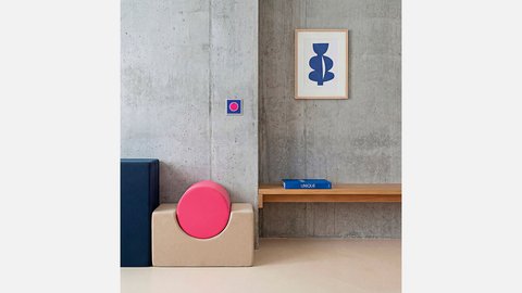 Betonwand mit modernen Möbeln und einem Bild an der Wand