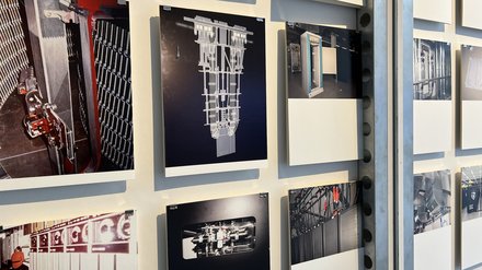 Mehrere Fotografien hängen einzeln mit Abstand an einer Wand. Zu sehen sind historische und moderne Technikräume: Rechenzentren, Schaltschränke, Kabelbündel und alte Computersysteme. Das Bild zeigt eine visuelle Erzählung der Entwicklung von Rechen- und Speichertechnologien. Es verdeutlicht die materielle Seite digitaler Systeme.