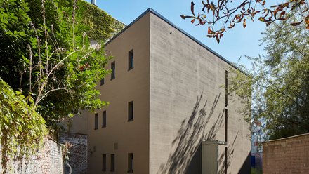 Eine Hinterhofbebauung umringt von Bäumen. 