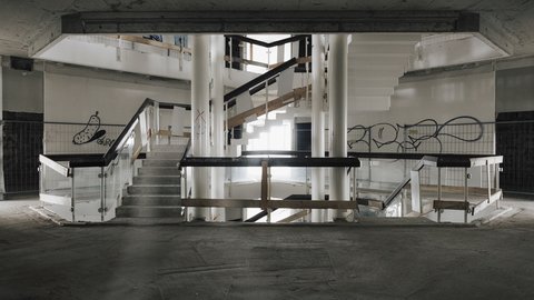 Zentrales Treppenhaus im Rohbau, mehrgeschossiger Luftraum mit Treppen, Geländern und sichtbaren Betonbauteilen.
