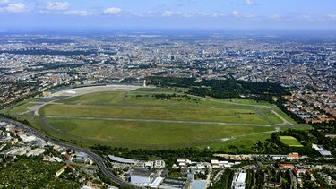 Luftaufnahme des Tempelhofer Feldes mit umliegender Stadt.