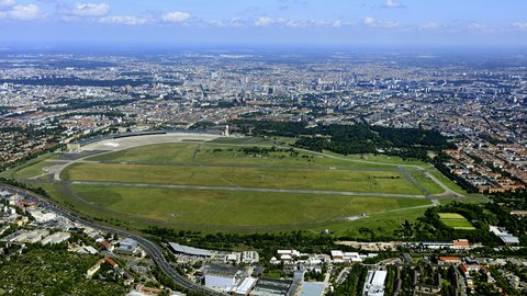 Luftaufnahme des Tempelhofer Feldes mit umliegender Stadt.