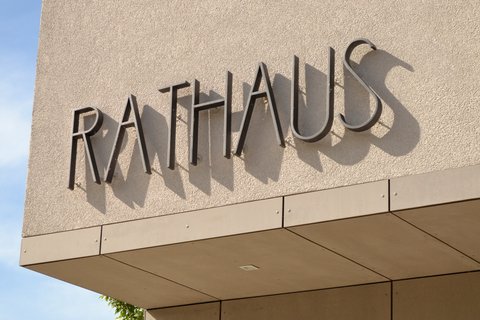 Schriftzug „Rathaus“ an der Fassade eines öffentlichen Gebäudes.