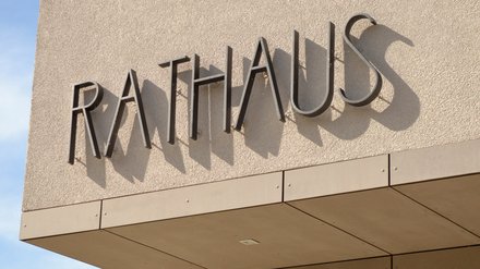 Schriftzug „Rathaus“ an der Fassade eines öffentlichen Gebäudes.