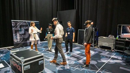 VR-Demonstration: Teilnehmende testen Virtual-Reality-Anwendungen in einem Ausstellungsbereich.