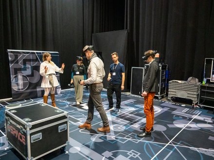 VR-Demonstration: Teilnehmende testen Virtual-Reality-Anwendungen in einem Ausstellungsbereich.
