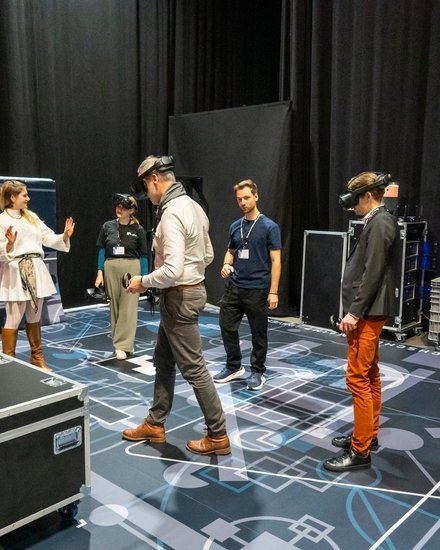 VR-Demonstration: Teilnehmende testen Virtual-Reality-Anwendungen in einem Ausstellungsbereich.