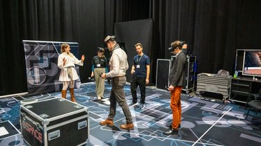 VR-Demonstration: Teilnehmende testen Virtual-Reality-Anwendungen in einem Ausstellungsbereich.