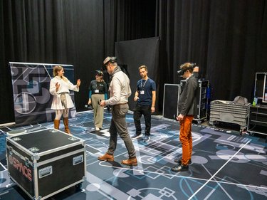 VR-Demonstration: Teilnehmende testen Virtual-Reality-Anwendungen in einem Ausstellungsbereich.