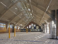 Sandhalle mit Volleyballfeld unter Holzdachkonstruktion