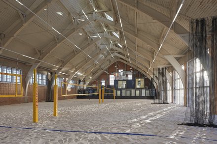 Sandhalle mit Volleyballfeld unter Holzdachkonstruktion