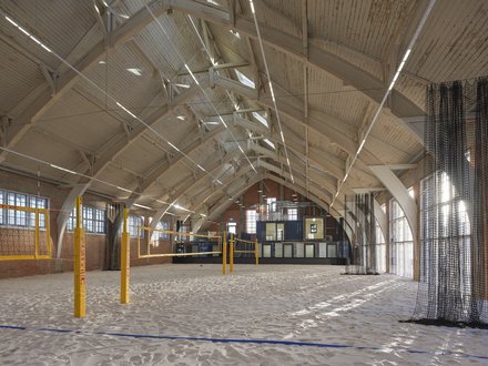 Sandhalle mit Volleyballfeld unter Holzdachkonstruktion