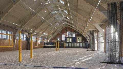 Sandhalle mit Volleyballfeld unter Holzdachkonstruktion