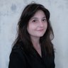 Porträt von Flavia-Ioana Biianu, einer Frau mit dunklen Haaren vor einer hellen Wand.