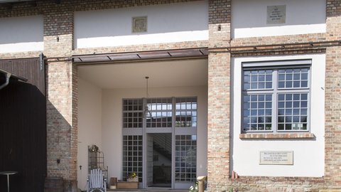 Saniertes Wohnhaus mit Ziegel- und Putzfassade sowie großzügigem Hofeingang.