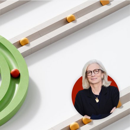 Abstrakte 3D-Grafik mit weißen parallelen Bahnen und gelben Kugeln; eine grüne Spur biegt ab und führt eine rote Kugel. Unten rechts ist ein Porträt einer grauhaarigen Frau mit Brille in einem roten Kreis eingeblendet