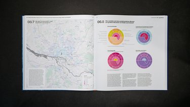 Aufgeschlagene Buchseite mit Karte und Kreisdiagrammen zur Bevölkerungsstruktur.