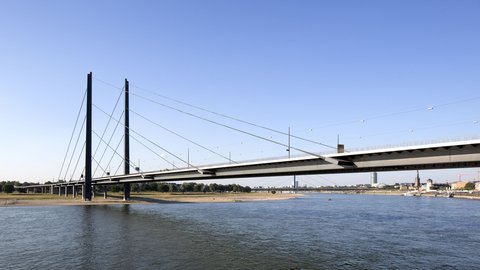 Ausschnitt der Rheinkniebrücke; Im Vordergrund ist der Rhein abgebildet. Im Hintergrund ist das gegenüberliegende Ufer zu sehen. 
