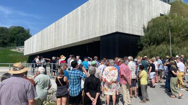 Außenansicht zeigt Betrachter vor dem Wasserkraftwerk in Töging am Inn