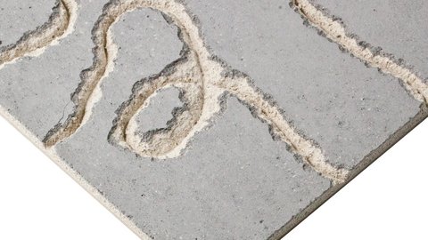 Betonplatte mit reliefartigen, geschwungenen Fräsrillen; Ecke der Platte im Bild.