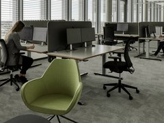 Modernes Großraumbüro mit Arbeitsplätzen und bodentiefen Fenstern
