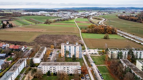 Luftaufnahme eines Wohngebiets am Stadtrand mit Feldern und Straßen.