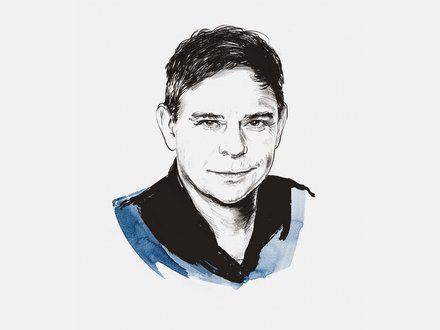Illustration eines Mannes in Strichzeichnungs-Stil mit schwarzer Tusche. Der Mann hat dunkles, nach oben gekämmtes Haar und blickt leicht lächelnd nach vorne. Er trägt einen schwarzen Pullover mit blauem Farbakzent an der Schulter. Der Hintergrund ist weiß.