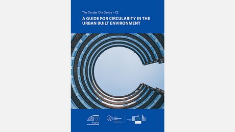 Das Bild zeigt das Titelblatt einer englischsprachigen Publikation mit dem Titel „A Guide for Circularity in the Urban Built Environment“. Zentral ist ein nach oben fotografierter, kreisförmiger Innenhof eines modernen Gebäudes zu sehen, der an ein großes „C“ erinnert. Am unteren Rand befinden sich Logos europäischer Institutionen. Zweck des Bildes ist es, einen internationalen Leitfaden zur Förderung von Kreislaufwirtschaft im städtischen Raum vorzustellen und den europäischen Kontext hervorzuheben.