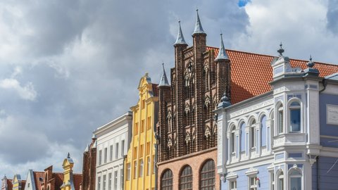 Historische, farbenfrohe Giebelhäuser in einer norddeutschen Altstadt unter bewölktem Himmel.