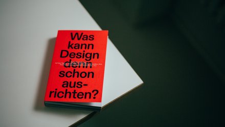 Foto des Readers „Was kann Design denn schon ausrichten?“ auf einem hellen Tisch