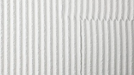 Helle Putzoberfläche mit parallelen, tiefen Rillen; Stoßfuge mit kleinen Zähnen in der Mitte.