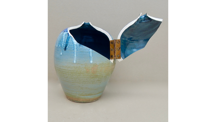 Hellblaue Keramikvase, oben aufgespalten; zwei Scherben über ein Messingscharnier verbunden, Innenfläche dunkelblau.