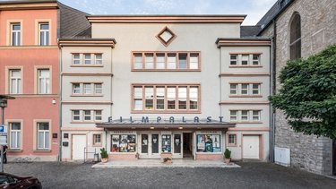 Außenansicht eines Kinos mit symmetrischer Fassade.