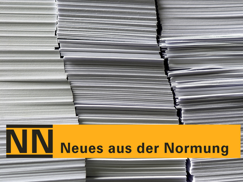 Hohe Stapel weißer Papierbögen; darüber ein gelber Balken mit der Aufschrift „NN – Neues aus der Normung“