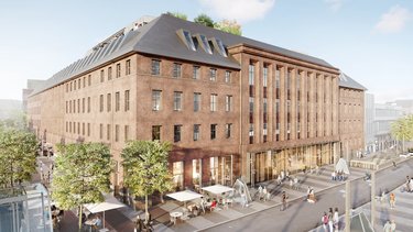 Historisches Backsteingebäude mit Erdgeschossnutzung und Menschen im öffentlichen Raum.