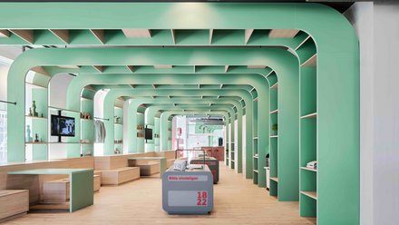 Moderner Ausstellungsraum mit mintgrünen Rundbögen, Holzpodesten und offenen Regalen.