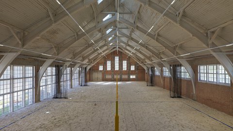 Symmetrische Ansicht einer Indoor-Sandhalle mit Volleyballnetz