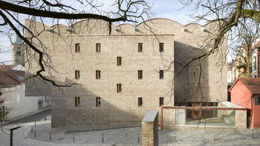 Außenansicht eines Backsteingebäudes mit geschwungenem Dach 